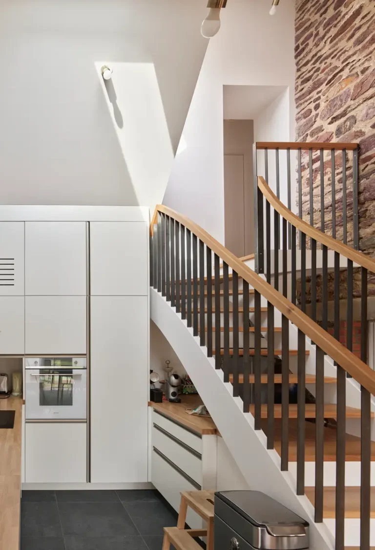 Escalier courbe en bois et métal dans une cuisine ouverte